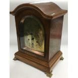 An oak cased 8 day mantle clock with an arch top,