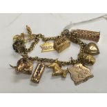 A gold charm bracelet with various attached charms