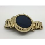 A Michael Kors smart watch with gold tone case and