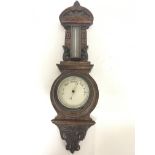 A carved oak wall barometer with mercury thermometer. 68cm.