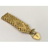 A modernist, gold plated gate bracelet with heart