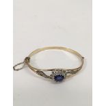 A 9ct rolled gold bangle set with blue and white s
