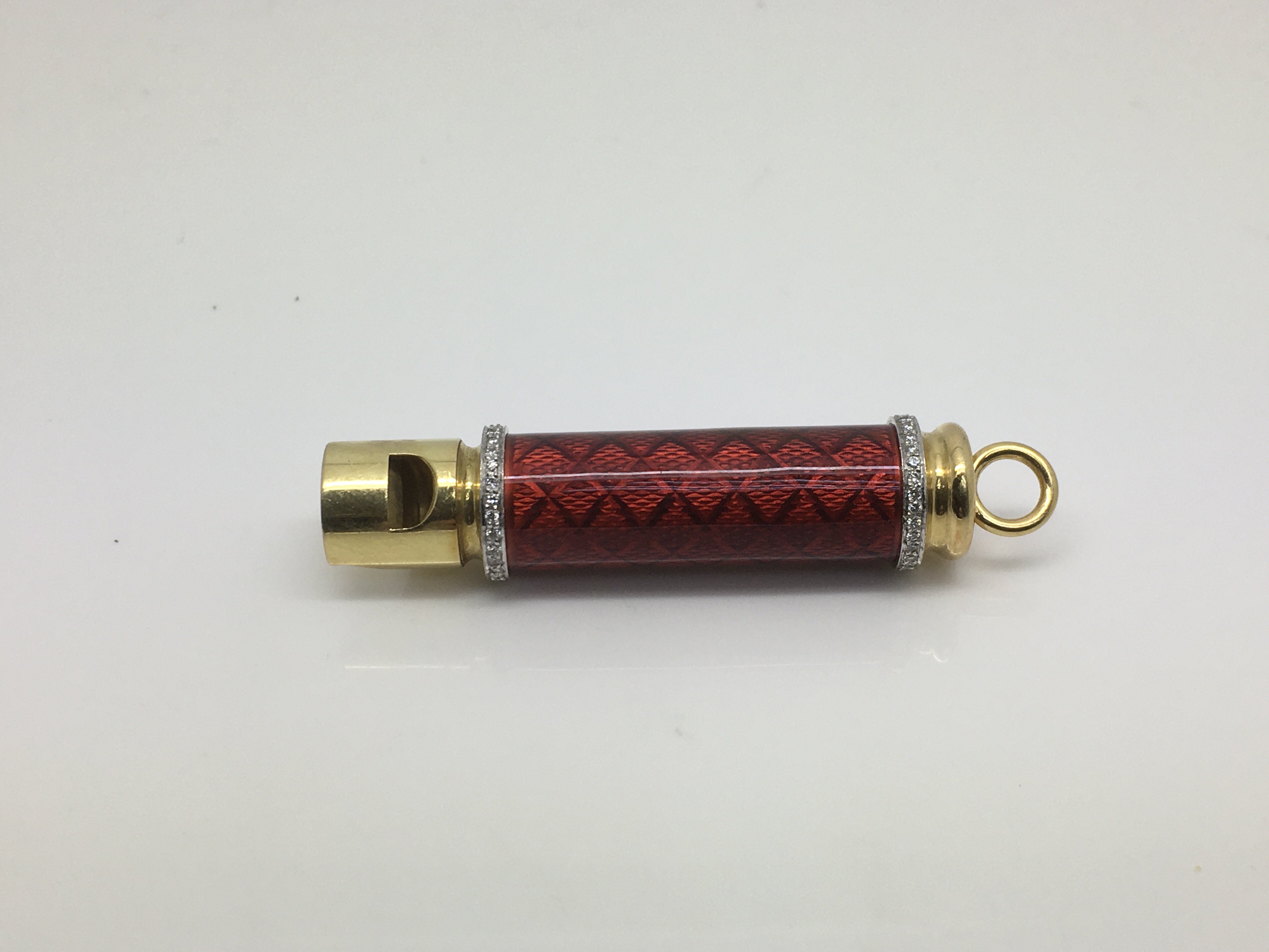 An 18ct gold diamond set whistle with engine turne