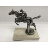 A chrome car mascot of a jockey on horseback raise