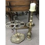 A heavy ornate brass stick stand and a large, Middle Eastern brass candlestick