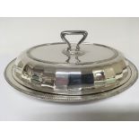 A solid silver entree dish of oval shape with a de