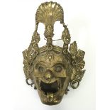 An unusual, Indian brass wall mask of a deity with fearsome expression.. Approx 4.5x 21cm h