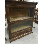 A oak two section globe style book case cabinet wi