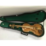 A cased violin with handwritten label inside.