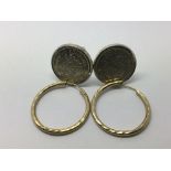 A pair of yellow metal hoop earrings and a pair of