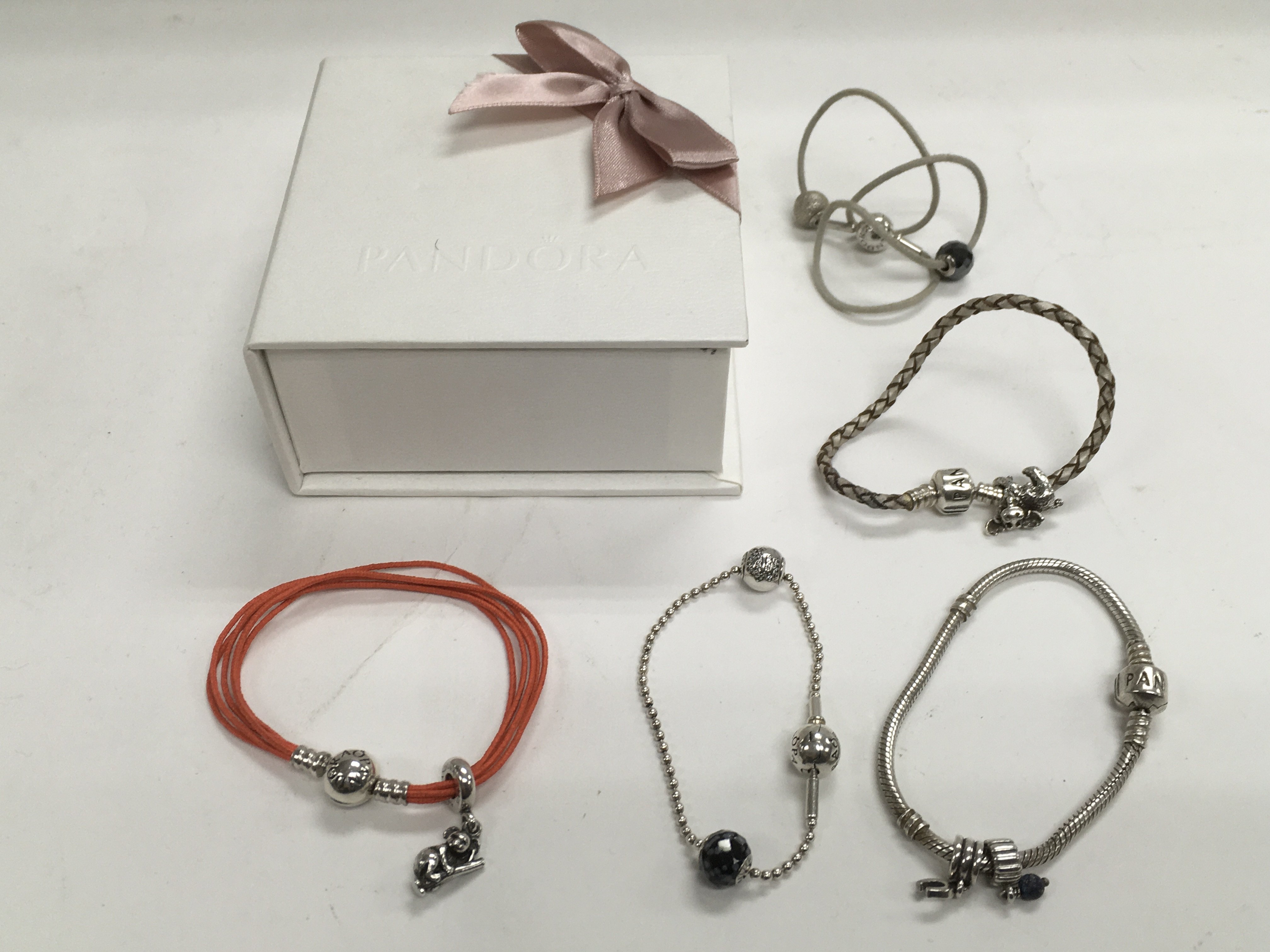 Five Pandora bracelets and charms.