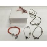 Five Pandora bracelets and charms.