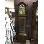 A smaller modern oak longcase clock with visible pendulum and rotating dial, approx 196cm.