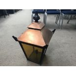 An outside copper lantern with four glass panels.