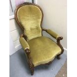 A Victorian nursing chair with green upholstery.