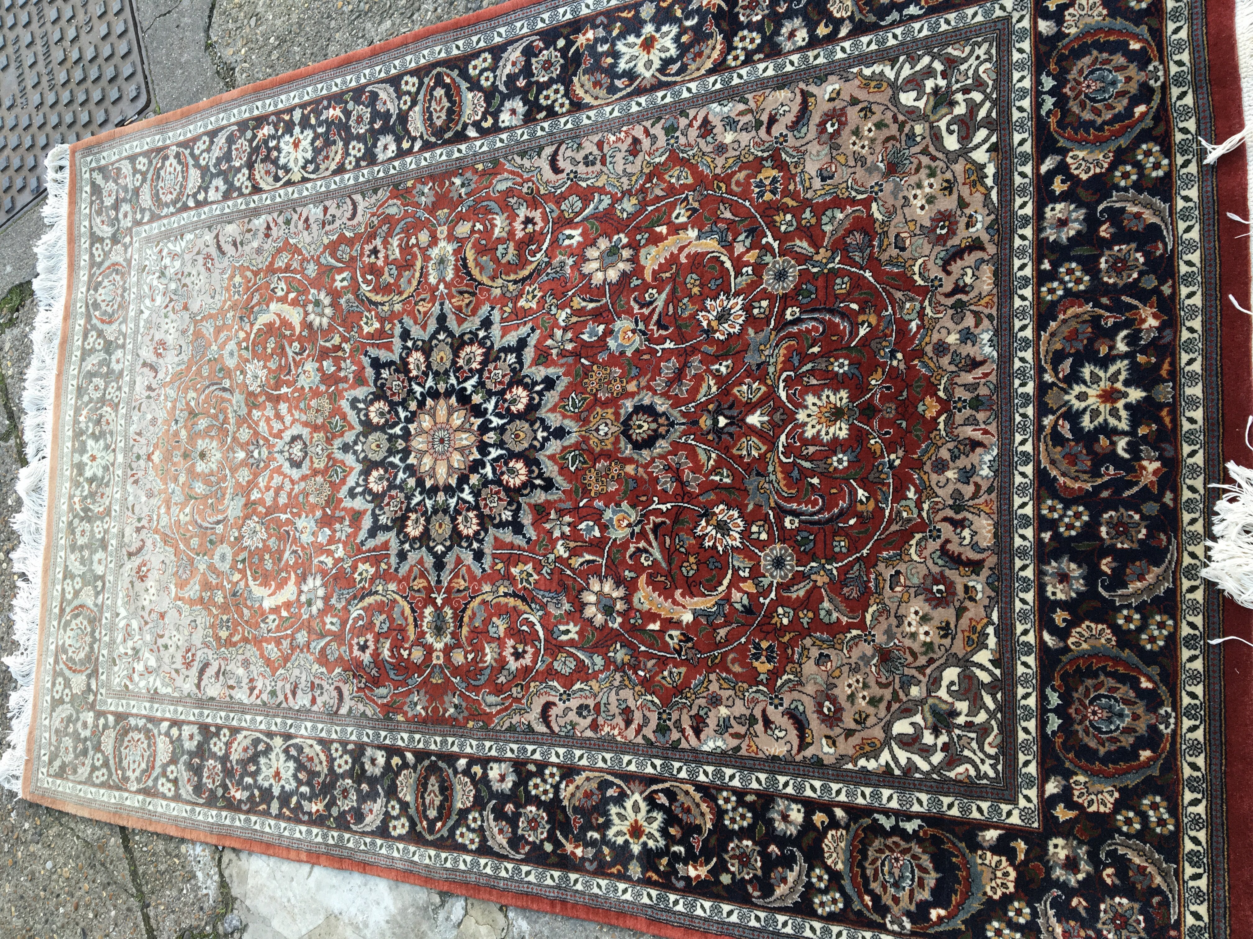 A hand knotted Persian rug with a large red centra