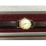 A small 18ct gold Omega watch with leather strap.