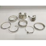 Eight silver bangles, various styles.