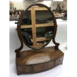 A bow fronted mahogany toilet mirror fitted with t