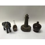 A serpentine stone lighthouse, lidded vase, an ena