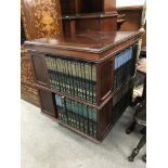 A revolving bookcase and books, approx 59.5cm x 59.5cm x 72cm.