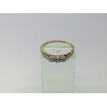 An 18ct gold ring set with three small diamonds, a