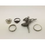 Four silver rings and a silver ballerina brooch (4