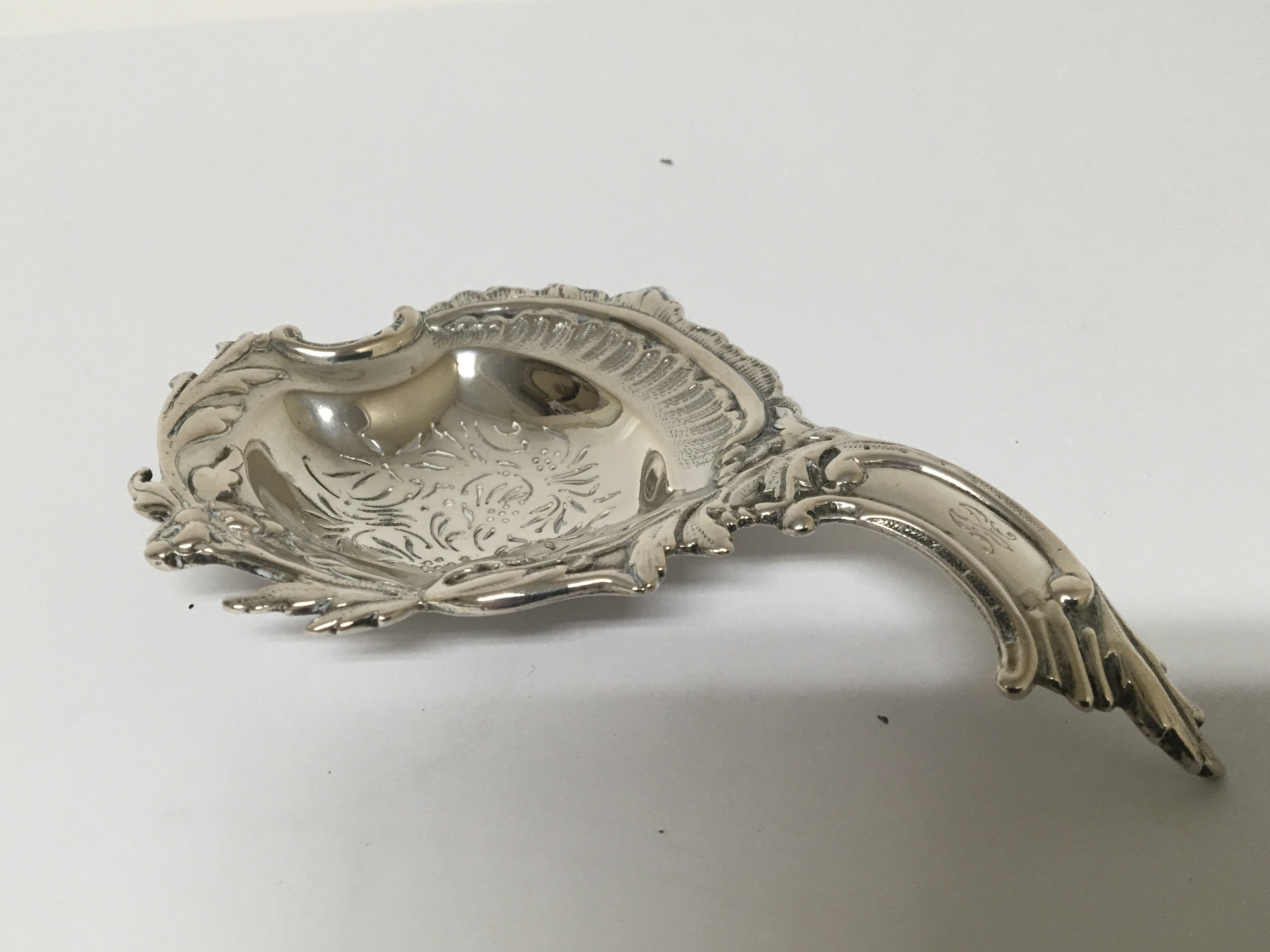 A white Continental metal tea strainer. of folate