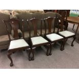 A set of four mahogany dining chairs with drop in