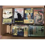 A box containing a collection of vintage paperback