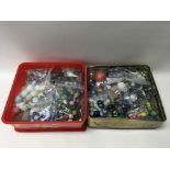 A quantity of various marbles contained within two tins, including a small group of Pokemon