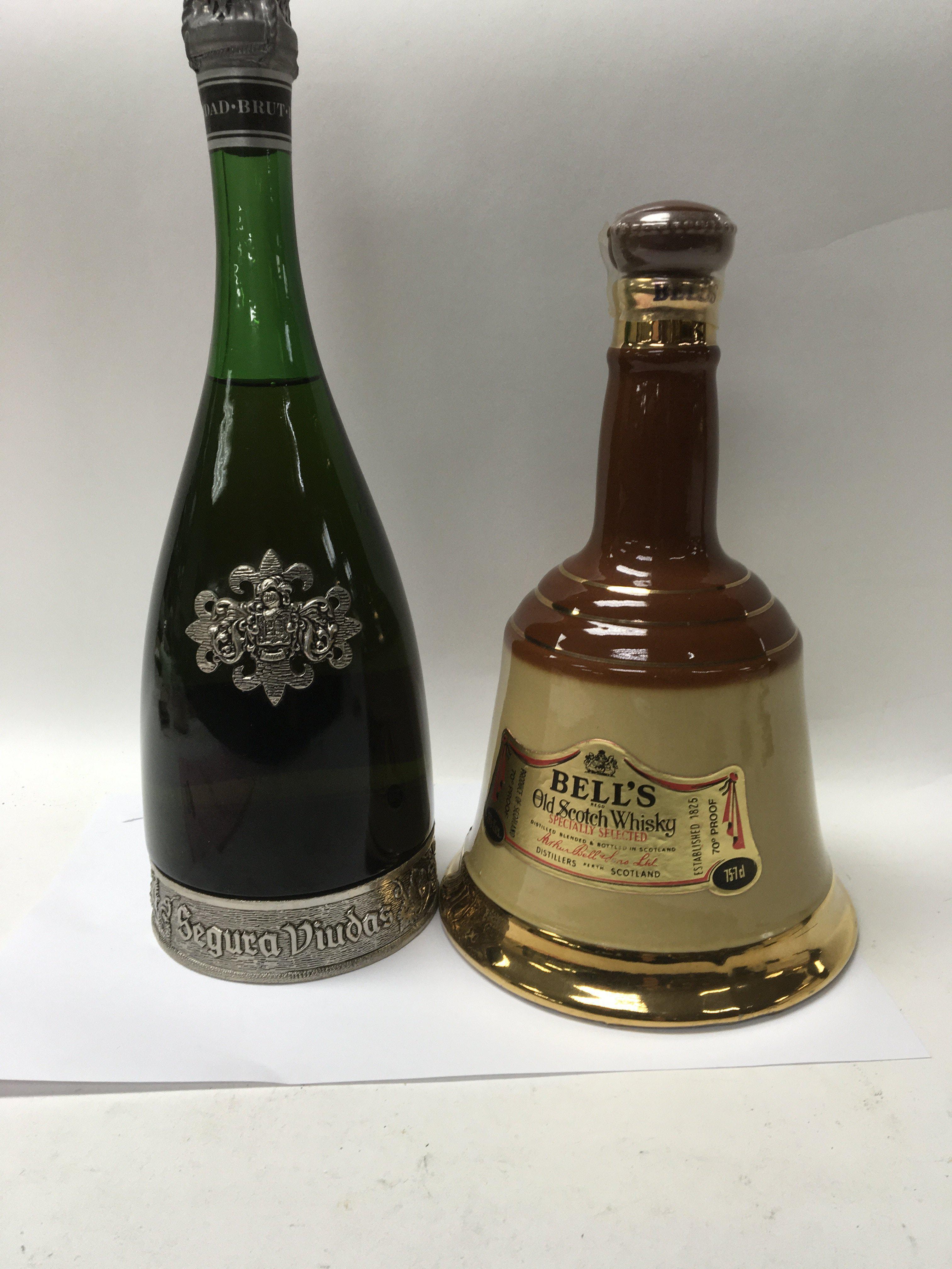 A bottle of bells scotch whisky and a bottle of segura viudas