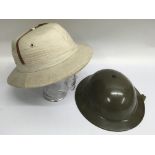 A military tin helmet and pith hat