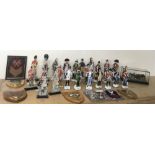 A collection of ceramic soldier figures, plus cloth badges and wall plaques