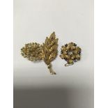 A 18 ct gold brooch of leaf form inset with rubies and two unmarked brooches