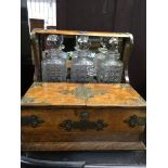 A oak tantalus with 3 glass decanters open section and a single drawer