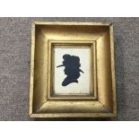 A gilt framed silhouette of a Georgian style lady wearing a hat