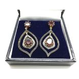 A pair of drop earrings m stamped 585 14ct and 925 silver set with garnets and diamonds, boxed