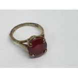 A 9ct gold ring set with a red stone.Approx 3.8g, L/M