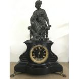 A scroll shaped, black mantle clock with gilt dial, surmounted with a bronzed female figure.Approx