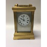 A gilt cased carriage clock with repeat button the silver dial with Roman numerals striking on a