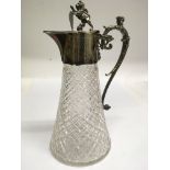 A cut glass claret jug with silver plated mount and lion finial