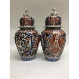 A pair of Japanese Imari vases and covers decorated in blue and iron red .35 cm .