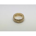 An 18ct gold wedding band with engraved decoration, approx 6.7g and approx size K-L.
