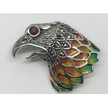 A silver eagle head brooch set with ruby eye, coloured enamel and marcasite