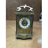 An ornate brass and 4 glass carriage clock.