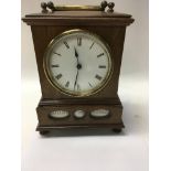 A unusual Victorian walnut mantle clock the circular dial with Roman numerals below inset with a