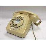 A rotary dial telephone in cream.