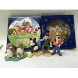A collection of sixteen Disney plates and a collection of Disney figures.