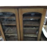 A mahogany bookcase with a pair of glazed doors on a plinth base